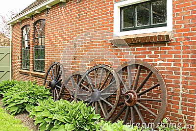 Antique wooden wheels against an old wall Editorial Stock Photo