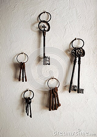 Antiques iron keys hanging on a house whitewashed wall Stock Photo