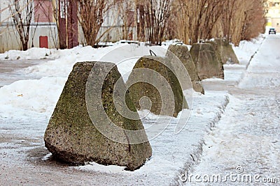 antiterrorist pyramidal concrete pedestals near the house beside the road against the entry of vehicles. Relevant when the danger Stock Photo