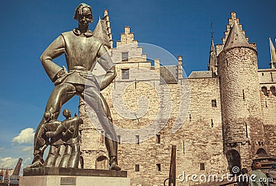 Giant figur of Lange Wapper, funny Flemish folkloric character and Medieval fortress Het Steen with brick walls Editorial Stock Photo