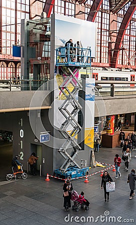 Antwerp, Belgium - 2018-10-01: Replacing a poster on the lift hoistway hig above the ground. Editorial Stock Photo