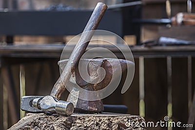 Anvil, hammer and mace displayed over cork oak stump Stock Photo