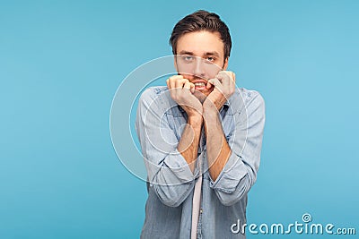 Anxiety disorder, depression. Portrait of stressed out, worried man in worker denim shirt biting nails Stock Photo