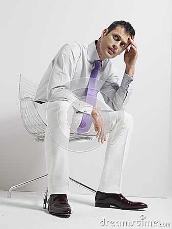 Anxious Businessman Sitting In Swivel Chair Stock Photo