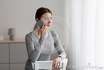 Anxious despair depressed upset caucasian young woman talking by phone, received bad news Stock Photo