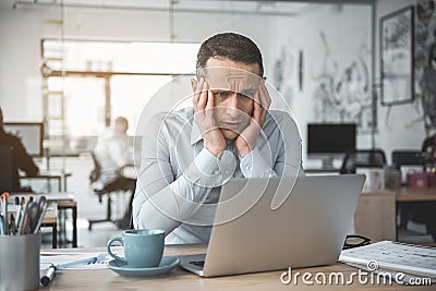 Anxious man looking at laptop Stock Photo