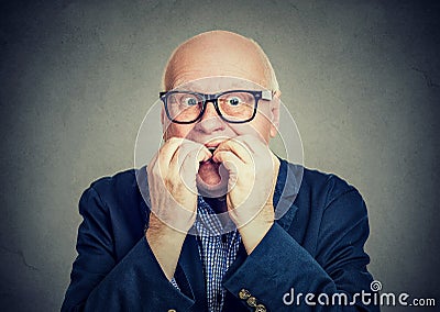 Anxious scared senior man biting fingernails Stock Photo