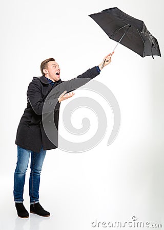 Anxious stressed young man with umbrella flying away Stock Photo