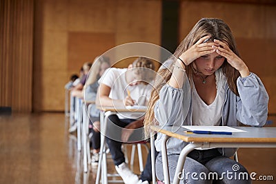 Anxious Teenage Student Sitting Examination In School Hall Stock Photo