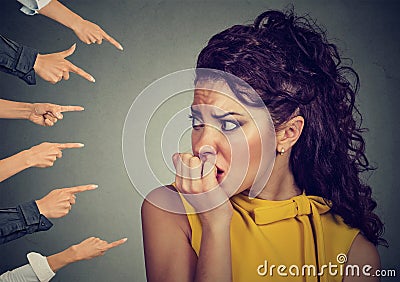 Anxious woman judged by different people fingers pointed at her Stock Photo