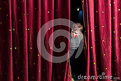 Anxious young actor looking out from the curtains Stock Photo