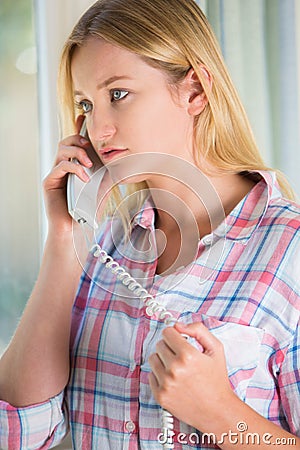 Anxious Young Woman Phoning Helpline Stock Photo