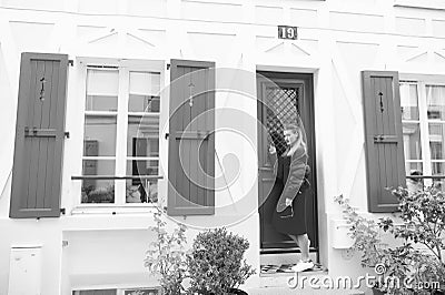 Anybody home. Lady guest knocking door waits owner apartment let her enter. Woman stylish outfit stand near door Stock Photo