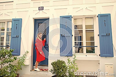 Anybody home. Lady guest knocking door waits owner apartment let her enter. Woman stylish outfit stand near door Stock Photo