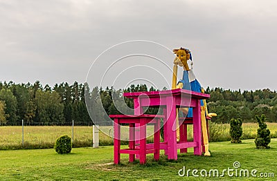 Giant wooden Buratino (Pinocchio) sitting at the table Editorial Stock Photo
