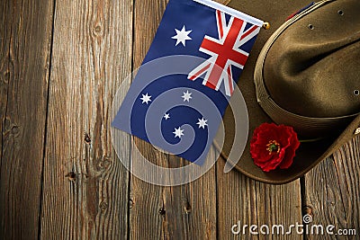 Anzac army slouch hat with Australian Flag and Poppy on wooden background Stock Photo
