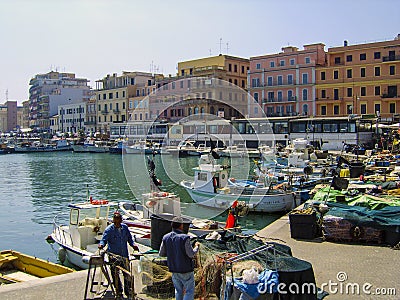 Fishermen repairing and preparing their nets on the quayside at Anzio, south of Rome, Italy. Editorial Stock Photo