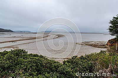 Aotea Harbor during the low tide under a cloudy sky in summer Stock Photo