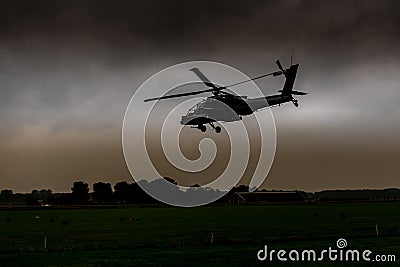 An Apache helicopter flies away to gilze Stock Photo