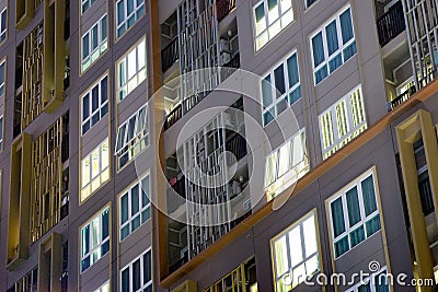 Apartment building complex in the city with condos and soft light glowing from the windows where occupants in well planned Stock Photo