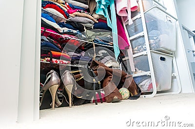 Real apartment closet organized and filled with woman`s clothes, depicting shopping, lifestyle habits, real life and clothing Stock Photo