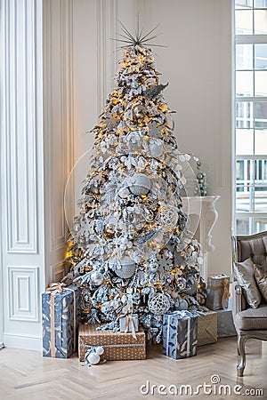 The apartment is decorated with a Christmas tree, under the tree are gifts Stock Photo