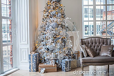 The apartment is decorated with a Christmas tree, under the tree are gifts Stock Photo