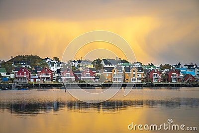 Apartment houses at the waterfront in Ballstad in front of yellow clouds at dawn Stock Photo