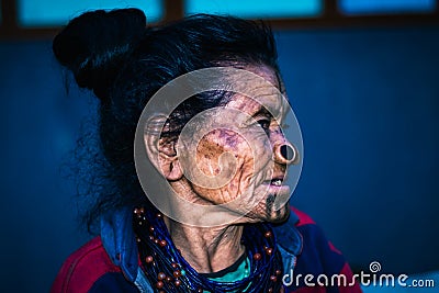 Apatani tribal women facial expression with her traditional nose lobes and blurred background Stock Photo