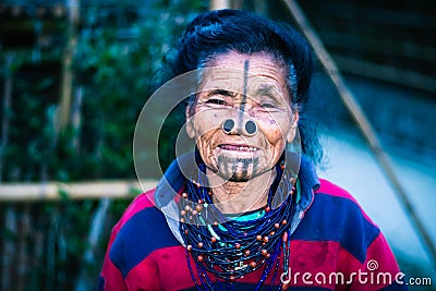 Apatani tribal women facial expression with her traditional nose lobes and blurred background Stock Photo