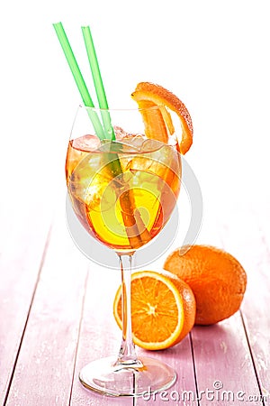 Aperol Spritz in a wine glass with ice cubes decorated with an orange slice on pink wooden background, summer cold drink Stock Photo