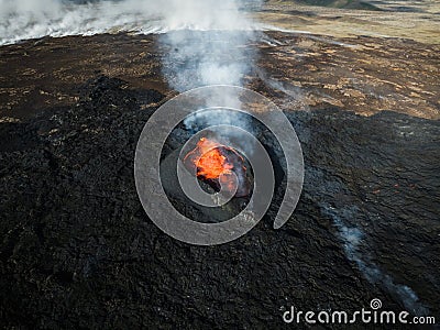 Apocalyptic surroundings of an erupted volcano, lava and smoke spreading, aerial Stock Photo