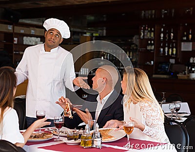 Apologetic pizzeria chef talking to dissatisfied guests Stock Photo