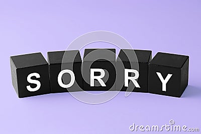 Apology. Word Sorry made of black cubes on violet background Stock Photo