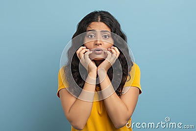 Appalled young indian woman touching her face Stock Photo