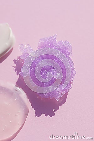 Appearance of the texture of the lilac sugar scrub on pink background. Cosmetic smear. Stock Photo