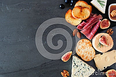 Assorted cheeses and meats, top view side border on a dark background with copy space Stock Photo