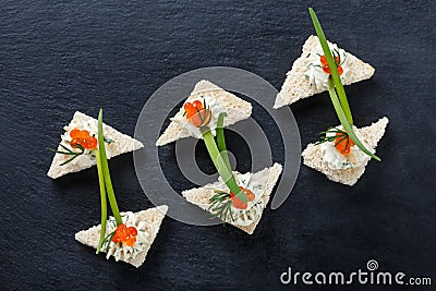 Appetizer canape with red caviar and cream cheese on stone slate background close up. Stock Photo