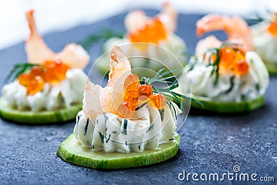 Appetizer canape with red caviar, shrimp and cream cheese on stone slate background close up. Stock Photo