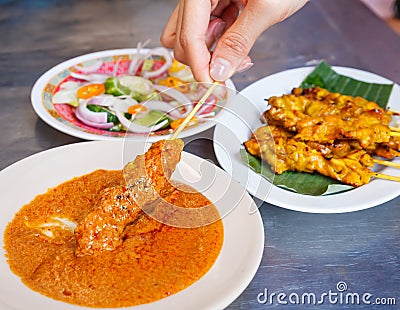 Appetizer dish of traditional Thai street food recipe, Pork Satay Grilled pork stick putting on banana leaf in white plate served Stock Photo
