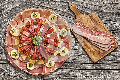 Appetizer Savory Dish Meze With Bacon Rashers On Cutting Board Set On Old Knotted Cracked Wooden Picnic Table Stock Photo