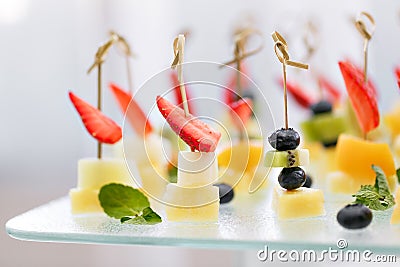 Appetizers, gourmet food - canape with cheese and strawberries, blue-berries catering service. selective focus, top view Stock Photo