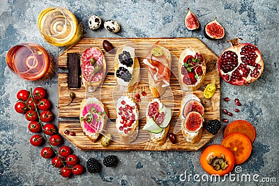 Appetizers table with italian antipasti snacks and wine in glasses. Brushetta or authentic traditional spanish tapas set Stock Photo