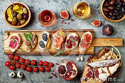 Appetizers table with italian antipasti snacks and wine in glasses. Brushetta or authentic traditional spanish tapas set Stock Photo