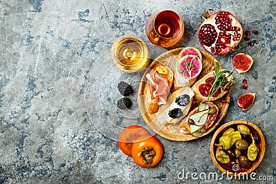 Appetizers table with italian antipasti snacks and wine in glasses. Brushetta or authentic traditional spanish tapas set Stock Photo