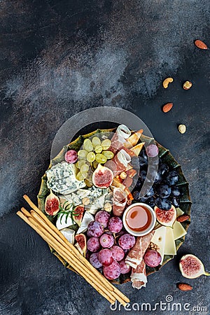 Appetizers table with italian antipasti snacks and wine in glasses. cheese, ham, nuts, fruit, bread sticks. Delicious balanced Stock Photo