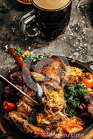 Appetizing Bavarian grilled pork knuckle with sauerkraut. Oktoberfest menu, German cuisine Stock Photo