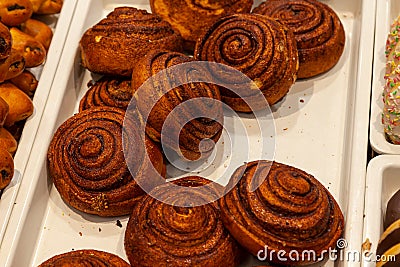 Appetizing big brown buns with cinnamon in the form of spirals c Stock Photo