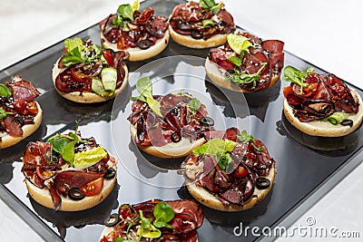 Appetizing canapes with meat sandwiches. Catering for business meetings, events and celebrations. Close-up Stock Photo