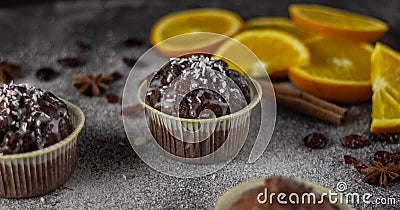 Appetizing close-up of a muffins on a dark background with slices of oranges Stock Photo